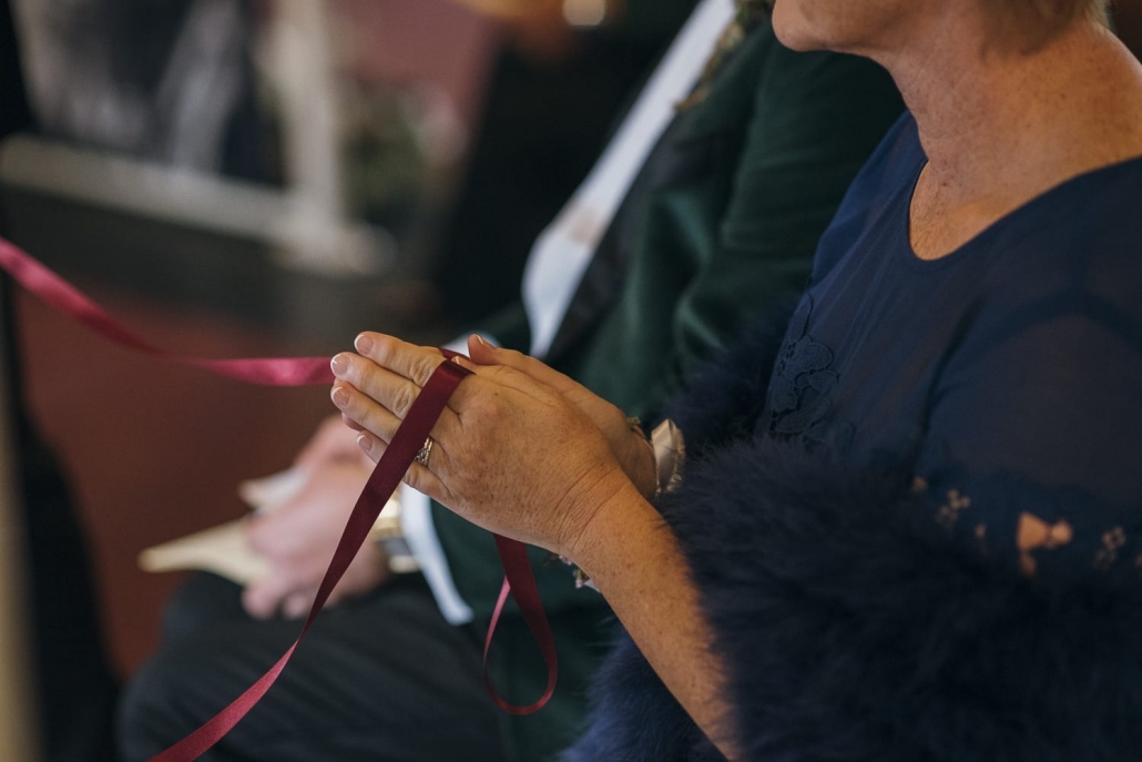 Wedding rings are looped on ribbon and held by the bride's mother